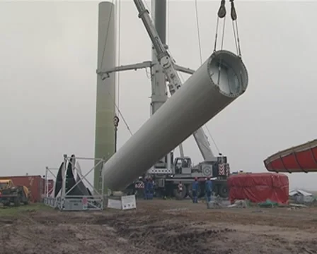 Crane lifting large part of windmill.  workers near it. Stock Footage 8973065