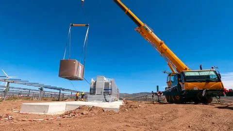 Crane lifting process for the assembly of electrical transformers in a phot.. Stock Photos