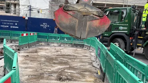 Crane lifting rubble from roadworks Stock Footage 247923149