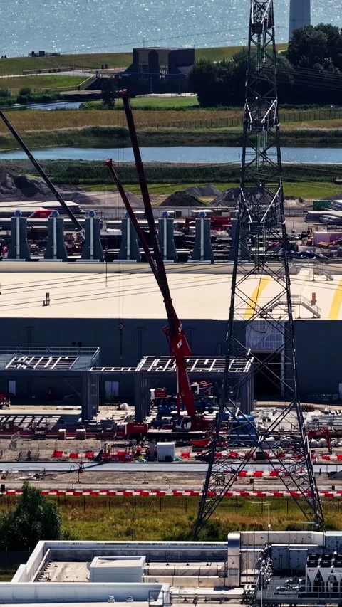 Crane lifting a section of a roof at a large data center construction site in Stock Footage 346575996
