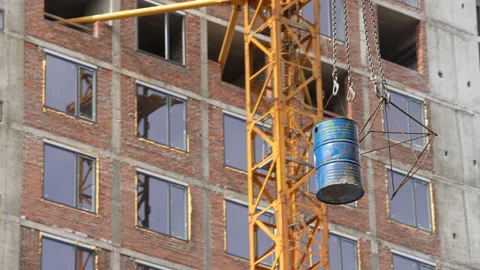 Crane lifts a construction barrel, at a construction site, during the day Stock-Footage 172264384