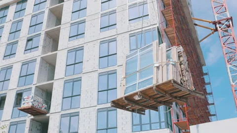 The crane lifts double-glazed windows. A crane raises windows for installation Vidéo 160159164