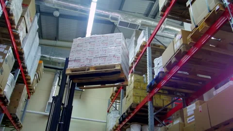 Crane lifts goods onto shelf with items in warehouse Stock Footage 238470977