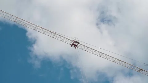 A crane lifts heavy materials as workers direct operations at a construction Video stock 339004506