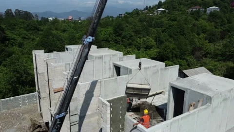 Crane lifts load to upper floors of construction site. Stock Footage 208561114