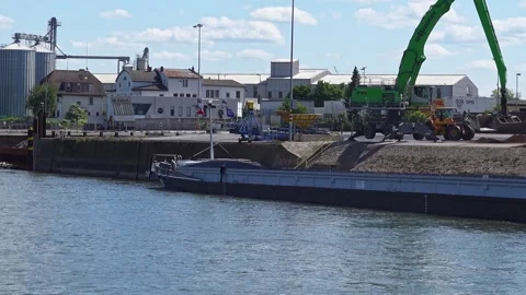 Crane loading barge with bulk material on rhine river Stock Footage 310041363
