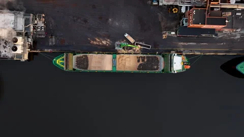 Crane loading cargo wood chip ship at industrial port paper mill Stock Footage 297055464