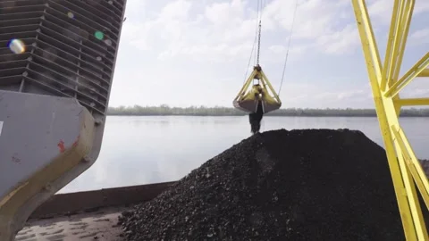 Crane loading coal onto a barge for northern delivery on the Yenisei River in Stock Footage 316008636