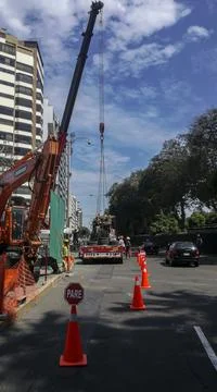 Crane loading a machine on a construction site in the open air Photos