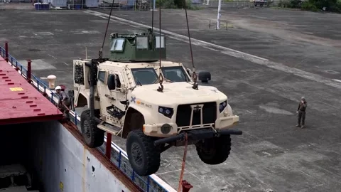 Crane loading military Joint Light Tactical Vehicle onto commercial vessel Video stock 278220848