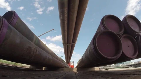 Crane loading offshore pipes onto flatbed truck Stock Footage 84299077
