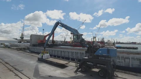 Crane loads cargo into freight ship hold in port timelapse Stock Footage 150775988