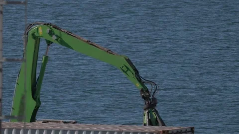 Crane loads containers onto ship at dock in sunny afternoon Stock Footage 334628345
