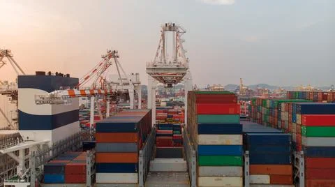 Crane loanding cargo container to container ship in the international termina Stock Photos