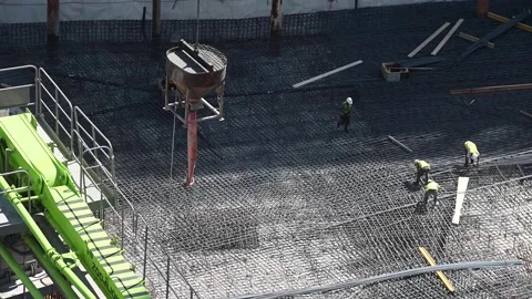 Crane lowering concrete bucket in a construction site 스톡 동영상 131127193