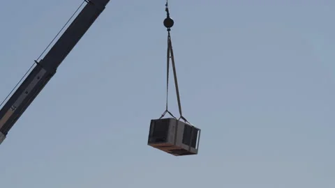 A crane lowering an old air conditioning unit from a rooftop Stock Footage 234427589