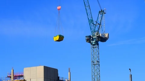 Crane lowering skip on building site in leeds yorkshire united kingdom Stock Footage 90388093