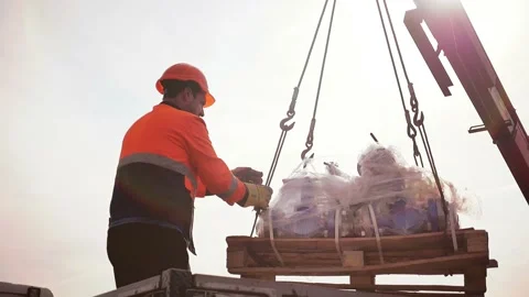 The crane lowers the load, the worker accepts the load, slow motion Stock Footage 142496019