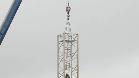 Crane machine holding part of tower crane and a worker controlling the process Video stock 153923469