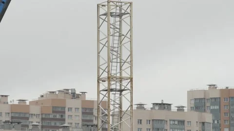 Crane machine lifting a part of high-rise crane and two workers assembling it Stock-Footage 153923377