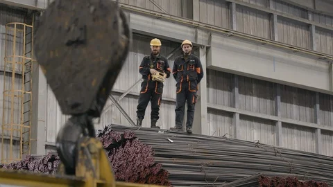 Crane moves a stack of steel bars at Emmar Steel Melting in Hassia, Syria Stock Footage 119765911