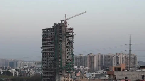 Crane moves on top of an under-construction building Stock Footage