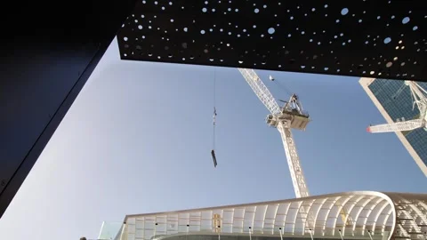 A crane moving materials pan to modern architecture in Sydney 4K Video stock 245523276