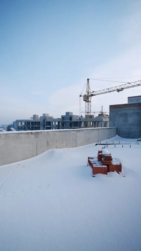 Crane next to a rooftop covered in snow Stock Footage 327842515