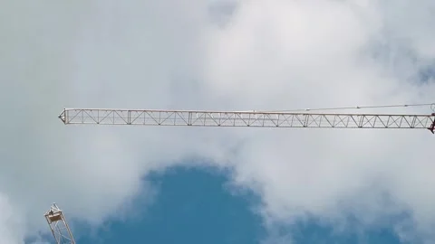 A crane operates at a construction site lifting materials against a backdrop of Stock Footage 339004318