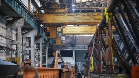 A crane is operating in the factory in the distance - the hook is lowered Stock Footage 110486642