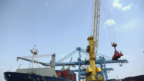 Crane operation at port loading containers onto large ship in bright daylight Stock Footage 318204185