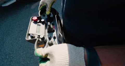 The crane operator controls the crane using the remote control of the crane. Stock Footage 147345404