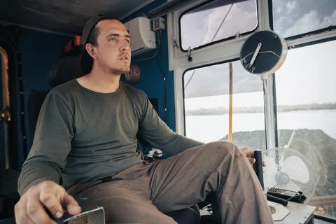 Crane operator controls the joystick of the crane, front side view inside the Stock Photos