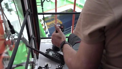 Crane operator inside cabin. Hand takes joystick and pull. Crane operator works Stock Footage 243393113