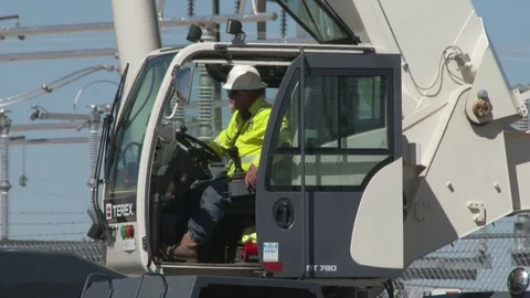A crane operator sits in cab of the crane as he controls it, 4K. Stock Footage 80930342