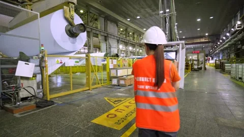 The crane operator unloads the finished paper in a roll from the paper machine Stockbeeldmateriaal 301971815