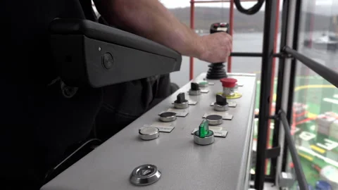 Crane operator works. Hand turns toggle switch on panel in crane cabin. Stock Footage 242540028