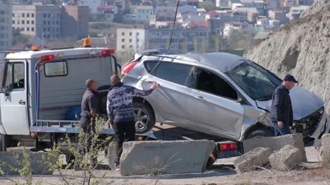 A crane pulled the wrecked car out of a deep hole. Evacuator. The victim of the Vidéo 145576281