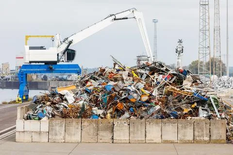 Crane at recycling facility loading large scrap metal pile with wind turbin.. Foto stock