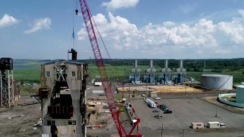 A Crane removing part of a tower at an old power plant Video stock 137243081