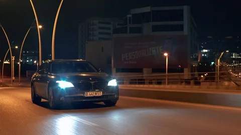Crane rolling shot of a BMW 7 Series luxury car driving on a bridge at night Video stock 125524017