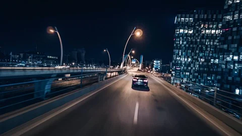 Crane rolling shot of a BMW 7 Series luxury car driving on a bridge at night Stock Footage 125524093