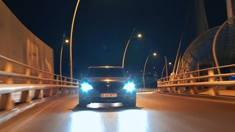 Crane rolling shot of a BMW 7 Series luxury car driving on a bridge at night Video stock 125524103
