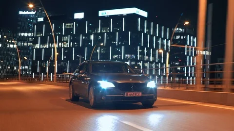 Crane rolling shot of a BMW 7 Series luxury car driving on a bridge at night Stock-Footage 125524116