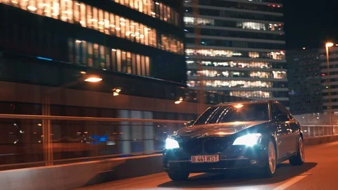 Crane rolling shot of a BMW 7 Series luxury car driving on a bridge at night Video stock 125524246