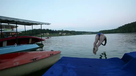 Crane shoot of man Jumping and swimming in the lake Stock Footage 27845097