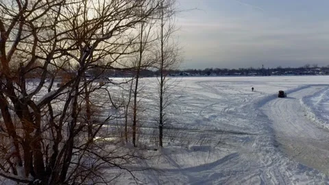 Crane shot from behind the trees showing the frozen river Stock-Footage 164346881