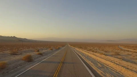 Crane shot of car driving off into desert on empty road Stock Footage 83929329