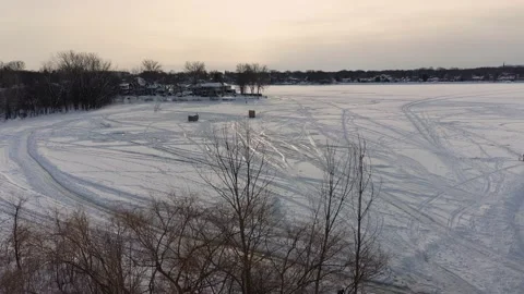Crane shot coming down slowly behind trees at sunset in winter in Laval Stock Footage 164344192