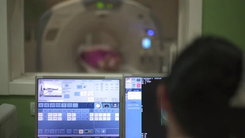 Crane shot from CT scanner to screen with x-ray images on screen in focus. Stock Footage